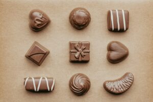 a group of milk chocolates ontop of a wooden mocha coloured table