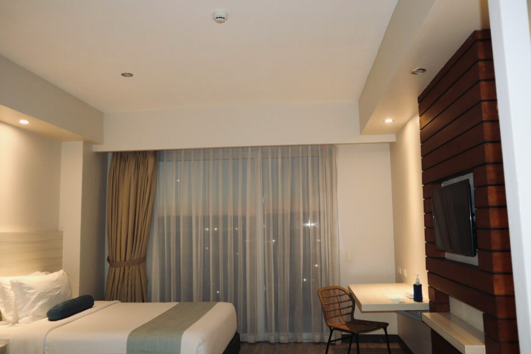A hotel room with a tv and a bed photo - Free Hotel Image on Unsplash