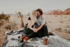 Man and woman sitting on blanket while holding each other hands photo - Free Woman Image on Unsplash