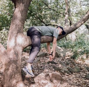 Man in black t-shirt and blue denim jeans sitting on branch photo - Free Relaxing Image on Unsplash