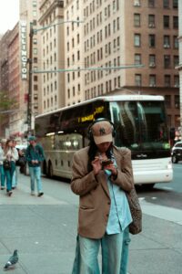 girl on phone in the street near bus