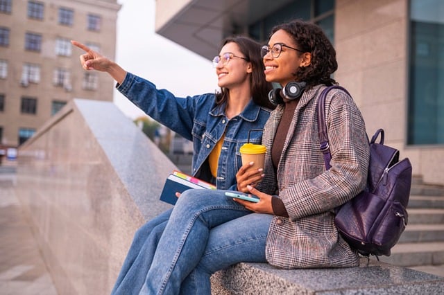 2 students sitting outside